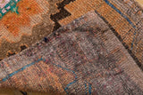 Distressed tangerine orange pile and handwoven foundation texture of the Oushak runner.