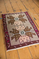 Distressed Oushak rug mat showing oversized brown motifs, silver field, and hot pink vine border.