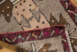 Folded corner of distressed Oushak rug, showing intact deep red side cord and pale pink tones.