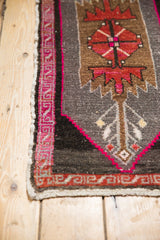 Vintage Oushak rug detail: germinating plant motif, bright fuchsia border, and intact selvage.