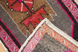 Vintage distressed Oushak rug's hand knotted pile texture, vibrant fuchsia edge, white selvage.