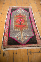 Distressed Oushak rug's bottom corner, with vibrant fuchsia and red serpent border pattern.