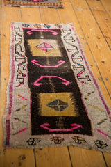 Distressed Oushak rug with hot pink pinwheel medallion, pale gold square, and running-t border.
