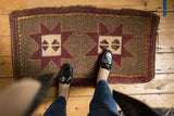 Distressed Oushak runner with aubergine starburst medallion and speckled coffee brown main field.