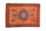 Distressed vintage Oushak rug mat with a burnt orange field and colorful roundel medallion.