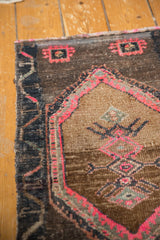 Hot pink geometric details on a distressed vintage Oushak rug's textured pile.