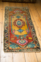 Distressed Oushak runner corner, showing worn pile texture and vibrant floral motifs.