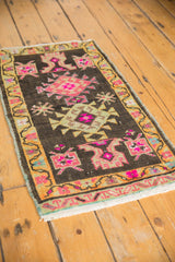 Corner of distressed Oushak rug, showing softened pile, saffron yellow meandering vine border.