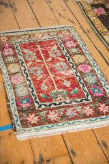 Angled perspective of a distressed Oushak mat, showing its worn red field and vibrant floral border.