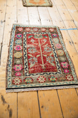 Colorful vintage Oushak mat showing even, distressed wear on its red tree of life motif.
