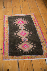 Distressed Turkish Oushak rug with hot pink diamond medallion and rust border.