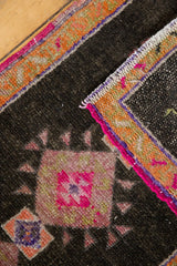 Distressed Oushak rug detail: hot pink medallion, bright orange border, and original pink selvage.