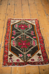 Distressed Oushak rug corner with vivid pink geometric patterns and worn pile texture.