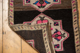 Original side cord selvage of a distressed Oushak rug mat with dark brown foundation.