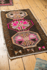Distressed Oushak lower gul medallion in hot pink, tangerine, dark brown, with intact selvage.