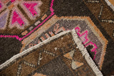Corner detail of distressed Oushak rug, revealing hot pink geometric pile and original selvedge.