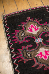 Distressed vintage Oushak rug corner showing hot pink pattern, worn pile, and zigzag selvage.