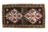 Hand-knotted vintage Oushak rug mat with double medallion, dated 1985, hot pink on dark field.