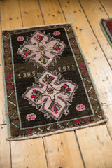 Vintage Oushak mat with hot pink medallion, 1985 date, and distressed texture.