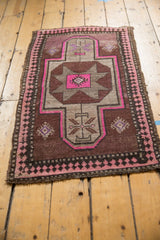 Blush and charcoal pawn motif border on a chocolate brown distressed Oushak rug.