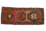 Distressed vintage Oushak runner with abrashed burnt orange field and triple bronze gul motifs.