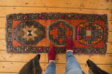 Vintage distressed Oushak runner, central oversized gul motif in abrashed burnt orange.
