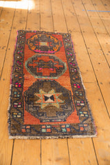 Starburst design motif on a distressed vintage Oushak runner in orange, yellow, and bronze.