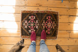 Low pile distressed Oushak mat, double floral medallions in pink, orange, and chocolate brown.