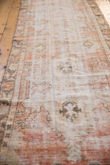 Distressed vintage Oushak runner showing faded orange-red and ivory tones with low pile.