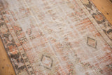 Faded distressed pile with mostly even wear, showcasing ivory, pale orange, and charcoal tones.