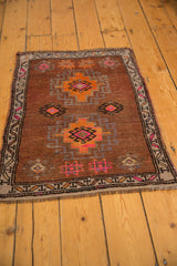 Distressed brown Oushak rug with pink, orange, and charcoal geometric hook and latch motifs.