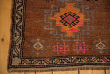 Distressed vintage Oushak rug corner, geometric border, tangerine and pink motifs, short fringe.