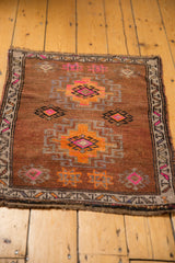 Distressed pile texture, fringed corner, and geometric border of vintage Oushak rug.