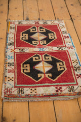 Vintage Oushak rug detail: cherry red and black geometric medallion, ivory border with colorful motifs.