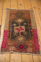 Distressed texture of geometric pattern in pale rust and charcoal, with fuchsia pink border.