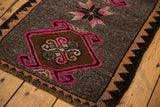 Distressed Oushak rug corner detail: bubblegum pink hook and latch, chocolate brown, and low pile fringe.
