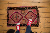 Distressed Oushak rug with geometric double diamond medallion in grapefruit red and pink.