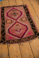 Distressed pink and charcoal Oushak rug detail with geometric diamond.