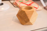 Natural cedar wood grain texture on the geometric facets of the planter's top opening.