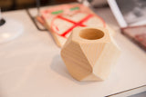 Geometric wood planter showing natural light cedar grain and faceted sides.