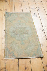 Fully secured fringed end of Vintage Distressed Oushak rug with worn apricot and mint pile.