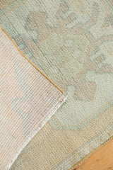 Hand-knotted foundation and distressed pile of vintage Oushak rug, faded mint and apricot.