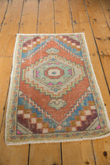 Distressed Oushak rug detail: concentric medallion, pale orange, sky blue, and visible pile wear.