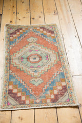 Geometric corner detail of the distressed Oushak rug, with faded orange, sky blue, and antique ivory.