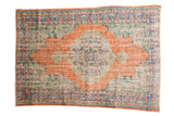 Vintage distressed Oushak carpet with prominent burnt orange medallion, mint green, and blue patterns.