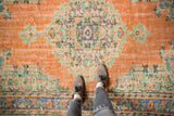 Large scalloped medallion in ivory, mint, and blue on the distressed Oushak rug.