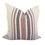 Loomination hand-woven multi-stripe pillow with cream, rust, navy, and teal stripes.