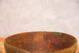 Hand-carved rim of a vintage African wood bowl showing etched patterns and aged texture.