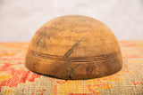 Vintage African wooden bowl close-up showing a prominent crack and carved lines.