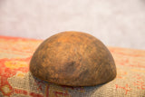 The curved exterior of a hand-carved African bowl with a rustic, aged patina.
